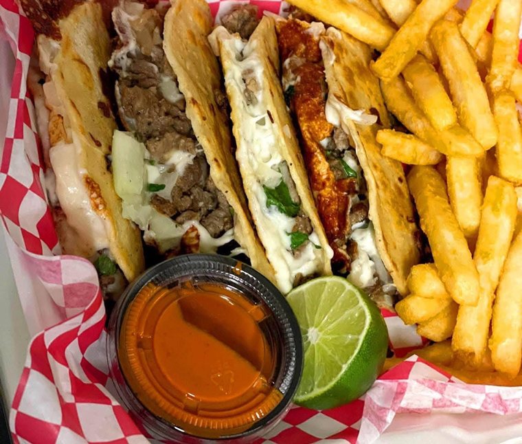 Asada quesotacos with fries, salsa and lime in a red basket. Photograph posted by Pumbah's Tacos & Burgers.