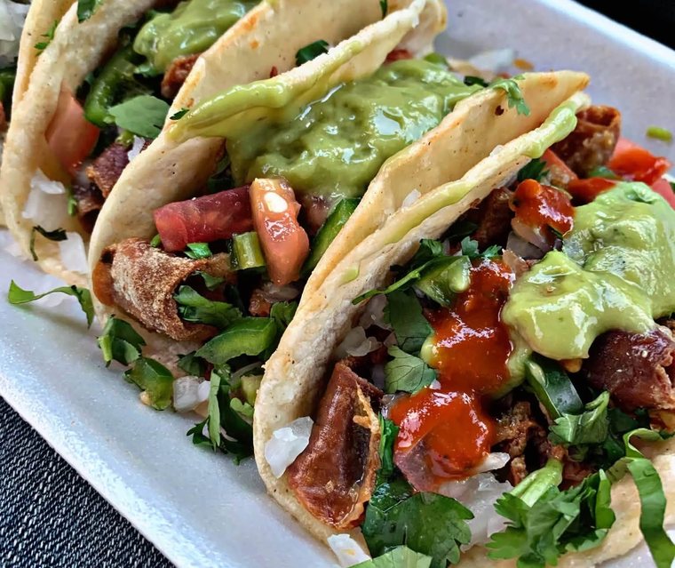 Loaded tripa tacos on soft tortillas with avocado salsa, cilantro and pico. Photograph posted by Pumbah's Tacos & Burgers.